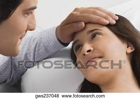 Stock Photo - Close-up of a mid adult man touching a young woman's head. Fotosearch