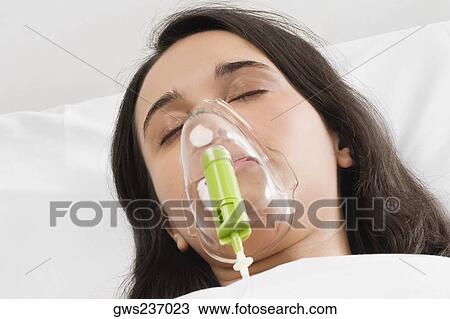 Close-up of a young woman wearing an oxygen mask View Large Photo Image Stock Image - Close-up of a young woman wearing an oxygen mask. Fotosearch