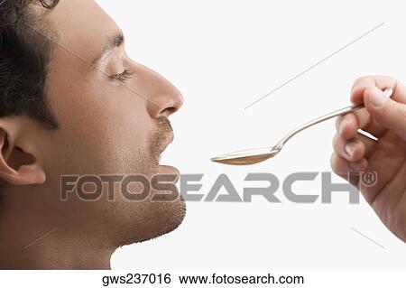 Stock Photograph - Doctor giving medicine to a mid adult man. Fotosearch