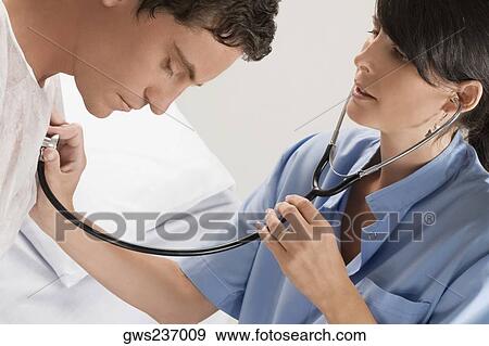 Stock Photo - Female doctor examining a mid adult man. Fotosearch