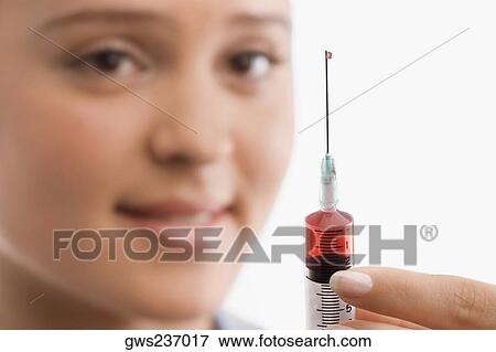 Female doctor holding a syringe View Large Photo Image Stock Photo - Female doctor holding a syringe. Fotosearch
