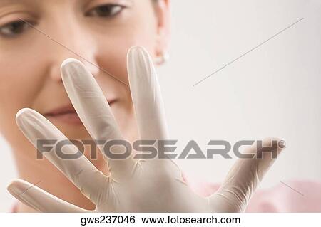 Female doctor wearing a surgical glove View Large Photo Image Stock Photograph - Female doctor wearing a surgical glove. Fotosearch