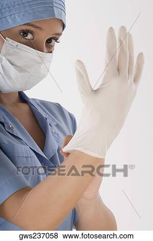 Female surgeon wearing a surgical glove View Large Photo Image Stock Photo - Female surgeon wearing a surgical glove. Fotosearch
