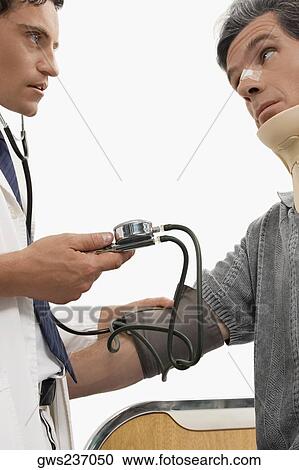 Male doctor checking blood pressure of a mature man View Large Photo Image Stock Image - Male doctor checking blood pressure of a mature man. Fotosearch
