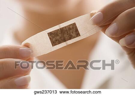 Mid section view of a female doctor holding an adhesive bandage View Large Photo Image Stock Image - Mid section view of a female doctor holding an adhesive bandage. Fotosearch