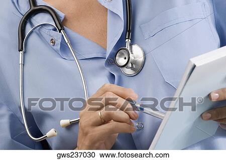 Mid section view of a female surgeon holding a pen and a notepad View Large Photo Image Stock Image - Mid section view of a female surgeon holding a pen and a notepad. Fotosearch