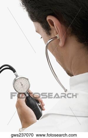 Rear view of a male doctor holding a blood pressure gauge View Large Photo Image Stock Image - Rear view of a male doctor holding a blood pressure gauge. Fotosearch