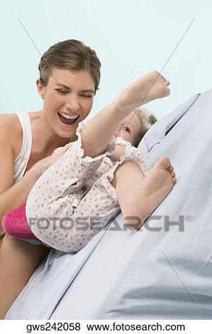 Stock Photo - Close-up of a mid adult woman playing with her daughter. Fotosearch