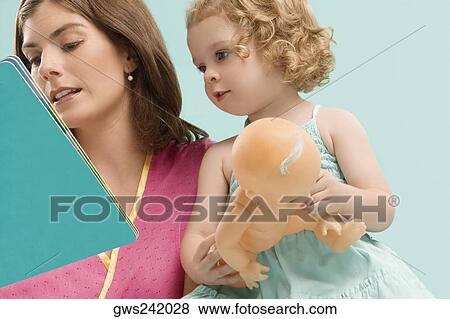 Close-up of a mid adult woman teaching her daughter View Large Photo Image Stock Photo - Close-up of a mid adult woman teaching her daughter. Fotosearch