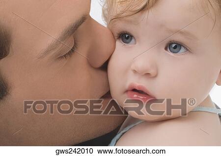 Close-up of a young man kissing his daughter View Large Photo Image Stock Image - Close-up of a young man kissing his daughter. Fotosearch