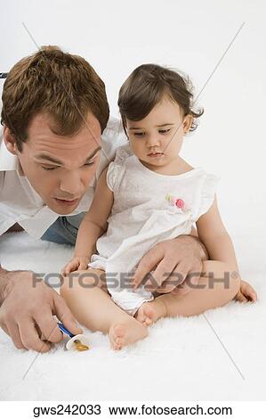 Stock Image - Close-up of a young man playing with his daughter. Fotosearch