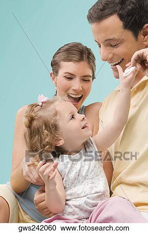 Mid adult couple playing with their daughter View Large Photo Image Stock Image - Mid adult couple playing with their daughter. Fotosearch