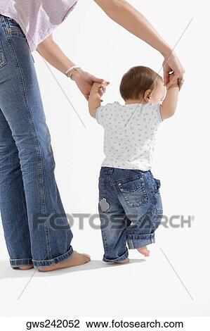 Rear view of a baby boy holding hands of his mother View Large Photo Image Stock Image - Rear view of a baby boy holding hands of his mother. Fotosearch