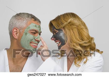 Close-up of a mature couple wearing facial masks and smiling View Large Photo Image Stock Photo - Close-up of a mature couple wearing facial masks and smiling. Fotosearch