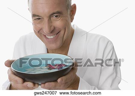Close-up of a senior man holding a bowl and smiling View Large Photo Image Stock Photo - Close-up of a senior man holding a bowl and smiling. Fotosearch