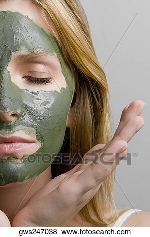 Stock Photo - Close-up of a teenage girl wearing a facial mask. Fotosearch
