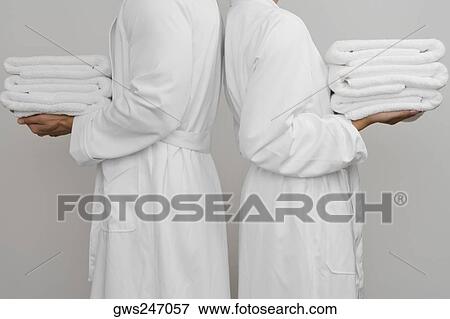Mid section view of a couple standing back to back and holding folded towels View Large Photo Image Stock Photo - Mid section view of a couple standing back to back and holding folded towels. Fotosearch