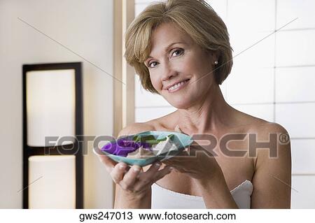 Portrait of a mature woman holding a bowl and smiling View Large Photo Image Stock Image - Portrait of a mature woman holding a bowl and smiling. Fotosearch