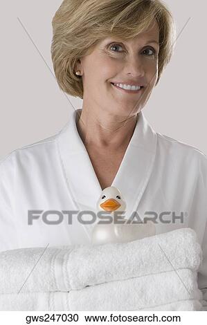 Portrait of a mature woman holding a stack of folded towels View Large Photo Image Stock Image - Portrait of a mature woman holding a stack of folded towels. Fotosearch
