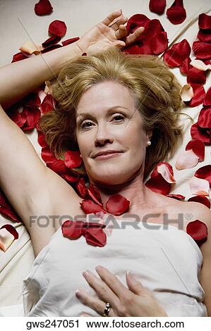 Portrait of a mature woman lying on a massage table and smiling View Large Photo Image Stock Image - Portrait of a mature woman lying on a massage table and smiling. Fotosearch