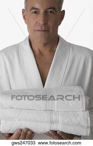 Portrait of a senior man holding a stack of folded towels View Large Photo Image Stock Image - Portrait of a senior man holding a stack of folded towels. Fotosearch