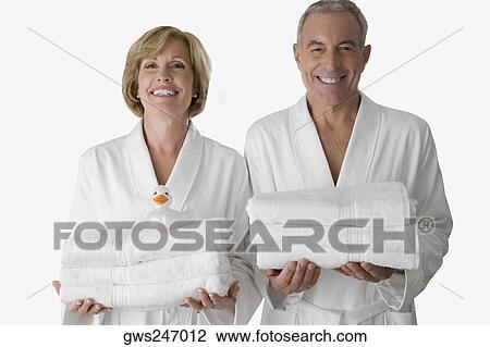 Portrait of a senior man with a mature woman standing together and holding folded towels View Large Photo Image Stock Image - Portrait of a senior man with a mature woman standing together and holding folded towels. Fotosearch