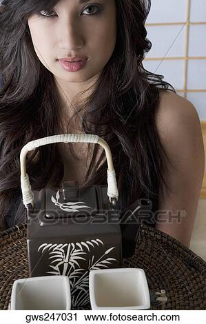 Portrait of a young woman holding a tray of two tea cups and a kettle View Large Photo Image Stock Image - Portrait of a young woman holding a tray of two tea cups and a kettle. Fotosearch