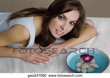 Portrait of a young woman lying on a massage table View Large Photo Image Stock Image - Portrait of a young woman lying on a massage table. Fotosearch