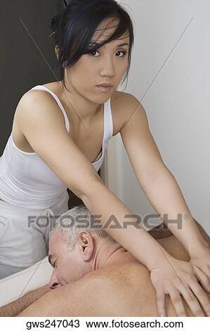 Rear view of a senior man getting a back massage from a massage therapist View Large Photo Image Stock Image - Rear view of a senior man getting a back massage from a massage therapist. Fotosearch