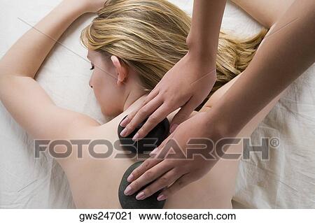Rear view of a teenage girl getting a back massage with therapeutic stones View Large Photo Image Stock Image - Rear view of a teenage girl getting a back massage with therapeutic stones. Fotosearch