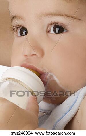Close-up of a baby boy drinking milk from a baby bottle View Large Photo Image Picture - Close-up of a baby boy drinking milk from a baby bottle. Fotosearch