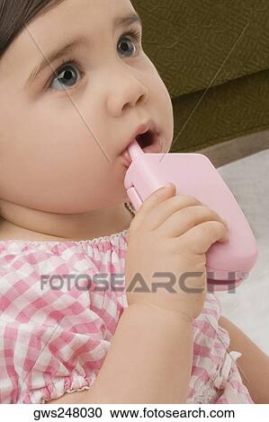Close-up of a girl holding a toy phone View Large Photo Image Stock Image - Close-up of a girl holding a toy phone. Fotosearch