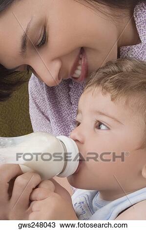 Close-up of a mid adult woman feeding her son with a baby bottle View Large Photo Image Stock Image - Close-up of a mid adult woman feeding her son with a baby bottle. Fotosearch