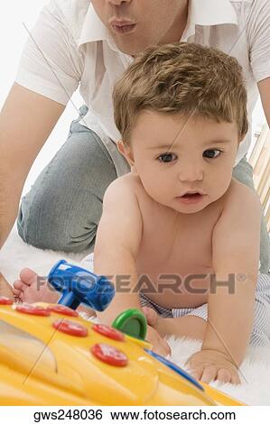 Close-up of a young man playing with his son View Large Photo Image Stock Photograph - Close-up of a young man playing with his son. Fotosearch