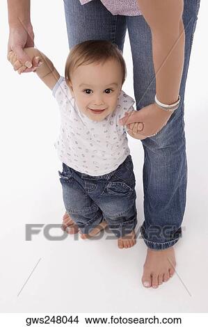 Portrait of a baby boy holding hands of his mother View Large Photo Image Picture - Portrait of a baby boy holding hands of his mother. Fotosearch