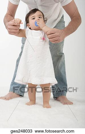 Stock Image - Portrait of a girl sucking a pacifier. Fotosearch