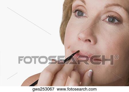 Close-up of a mature woman applying lip liner View Large Photo Image Stock Photo - Close-up of a mature woman applying lip liner. Fotosearch