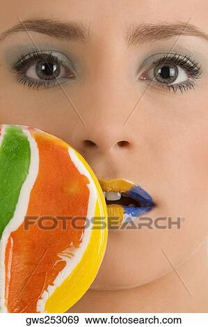 Close-up of a young woman with a lollipop View Large Photo Image Stock Photo - Close-up of a young woman with a lollipop. Fotosearch