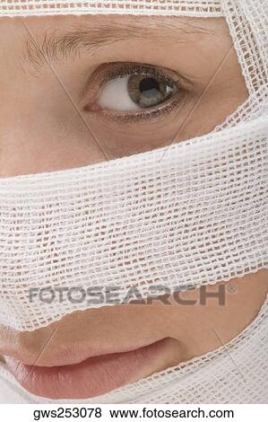 Close-up of a young woman's face wrapped with a bandage View Large Photo Image Stock Photo - Close-up of a young woman's face wrapped with a bandage. Fotosearch