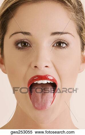Portrait of a young woman sticking her tongue out View Large Photo Image Stock Photography - Portrait of a young woman sticking her tongue out. Fotosearch