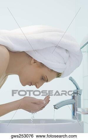 Side profile of a young woman washing her face View Large Photo Image Stock Photograph - Side profile of a young woman washing her face. Fotosearch