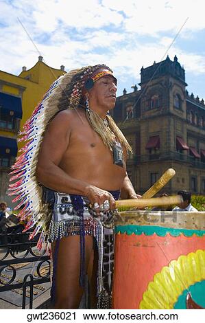 Stock Image - Mature man playing drums with drumstick, Zocalo, Mexico City, Mexico. Fotosearch