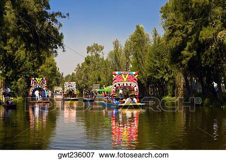 Stock Photo - Tourists on trajineras boats in a canal, Xochimilco Gardens, Mexico City, Mexico. Fotosearch