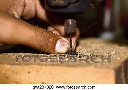 Stock Image - Close-up of a person's finger drilling, Izamal, Yucatan, Mexico. Fotosearch