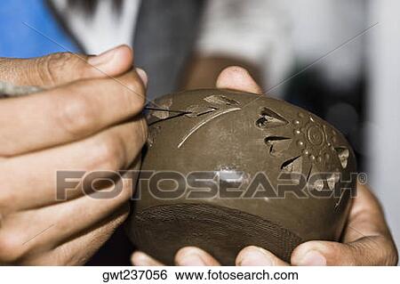 Stock Photograph - Close-up of a person's hand making pottery, San Bartolo Coyotepec, Oaxaca State, Mexico. Fotosearch