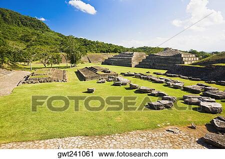 Stock Image - Old ruins on a grassy landscape, El Tajin, Veracruz, Mexico. Fotosearch