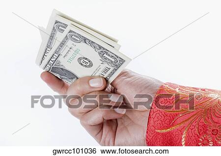 Stock Photograph - Close-up of a person's hand holding US paper currency. Fotosearch