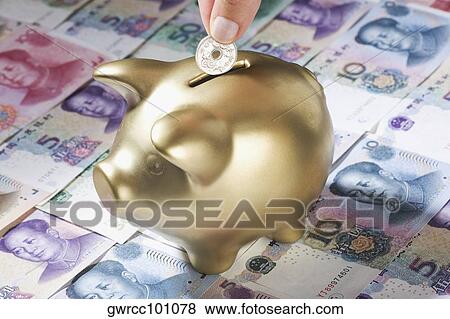 Close-up of a person's hand putting coin into a piggy bank View Large Photo Image Stock Photo - Close-up of a person's hand putting coin into a piggy bank. Fotosearch