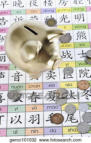 Stock Image - Piggy bank and coins on Chinese calendar. Fotosearch