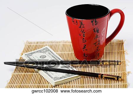Chopsticks with a stack of US paper currency and a cup on place mat View Large Photo Image Stock Photo - Chopsticks with a stack of US paper currency and a cup on place mat. Fotosearch
